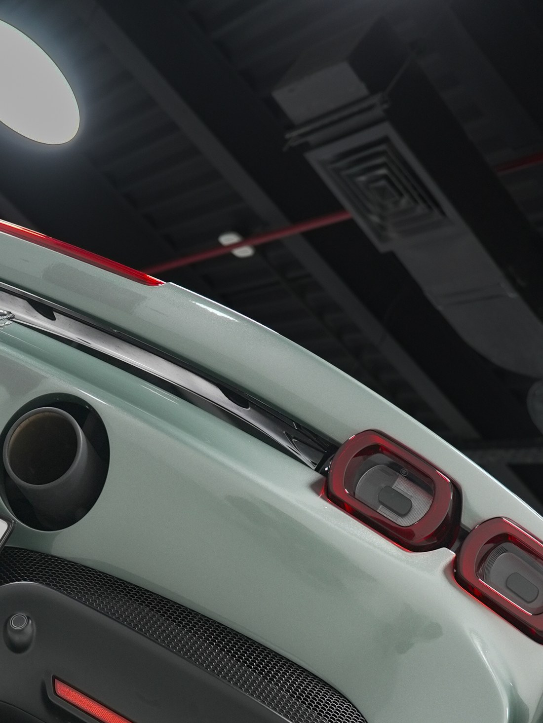 Carbon-bodied car detail under workshop lighting at Kynetik Koncepts, rear three-quarter