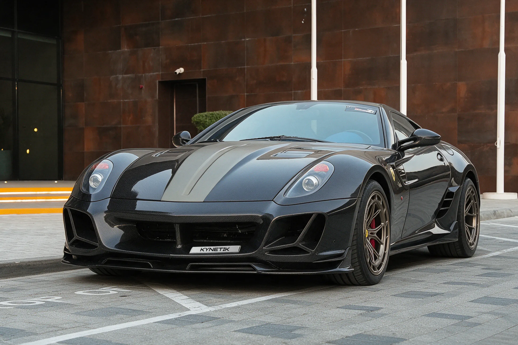 599 RF one-of-one by Kynetik Koncepts, exposed carbon fibre bodywork, front three-quarter outside the Dubai showroom