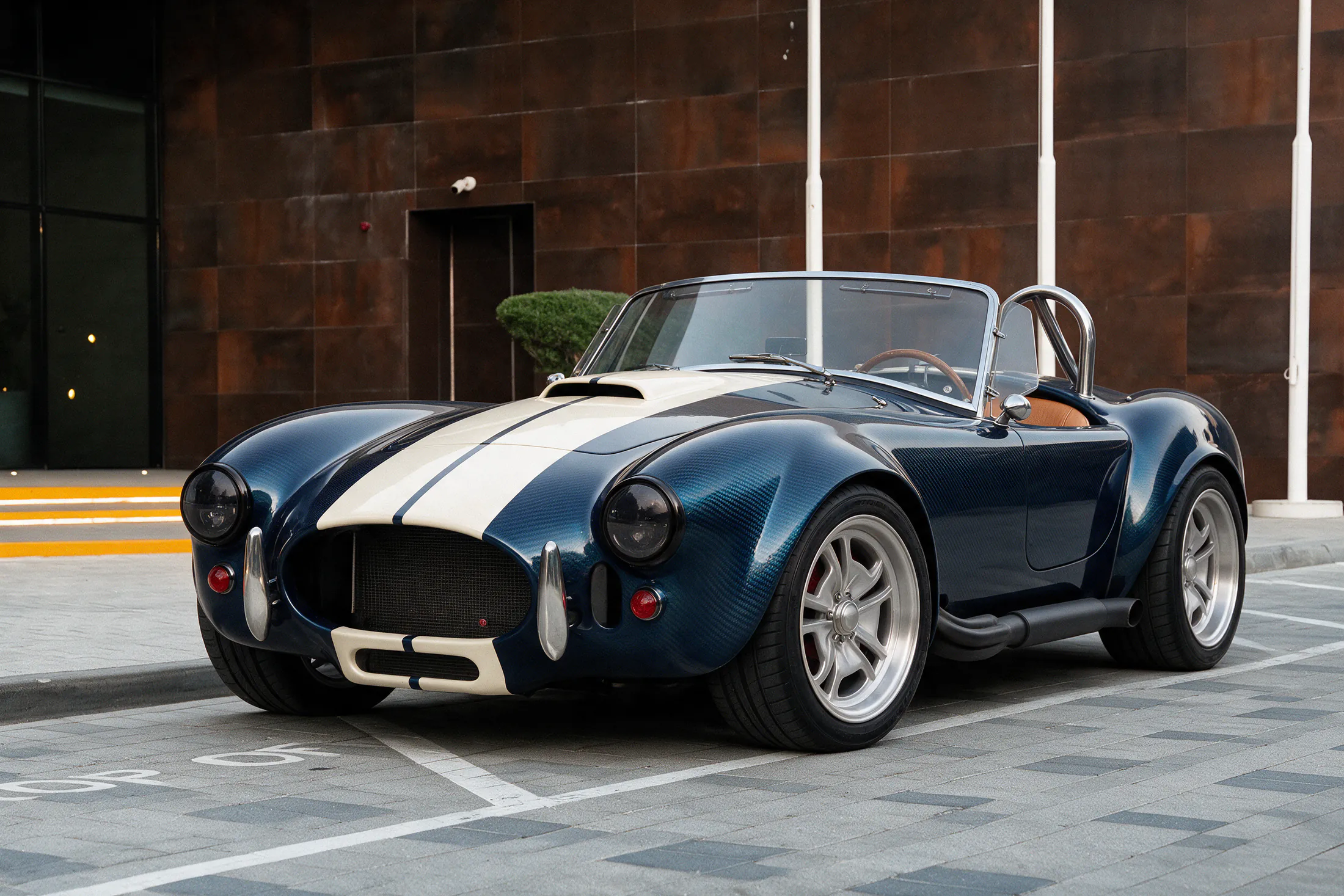 Karbon Kobra by Kynetik Koncepts, blue carbon fibre roadster with white racing stripes, front three-quarter outside the Dubai showroom