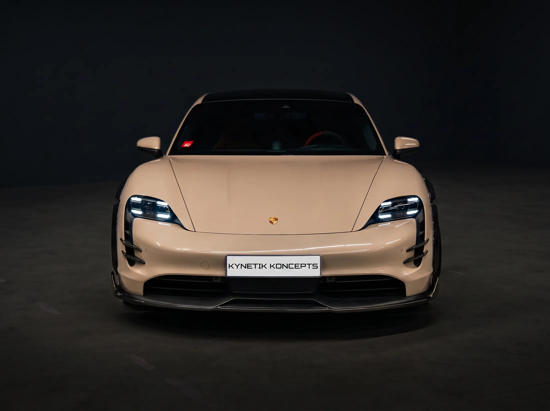 Porsche Taycan carbon fibre conversion by Kynetik Koncepts — front view, dark studio